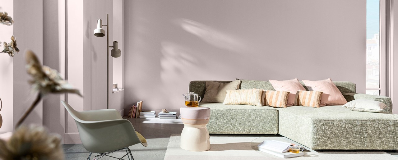 Living room with soft pink walls and grey sofa